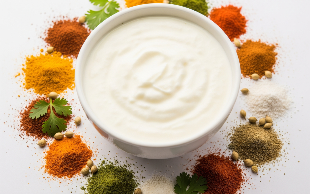 Creamy homemade Indian dahi (curd) in a white bowl, surrounded by vibrant scattered spices like turmeric and chili powder,
