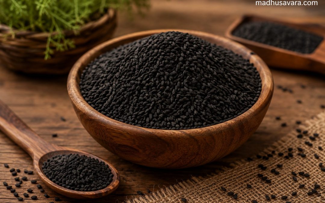 Wooden bowl filled with Kala Jeera (Himalayan Black Cumin) seeds on a rustic wooden table, with a wooden spoon, burlap cloth, and the watermark “madhusavara.com”.