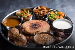 Delicious Ragi Mudde, Ragi Roti and traditional accompaniments served in Indian thali
