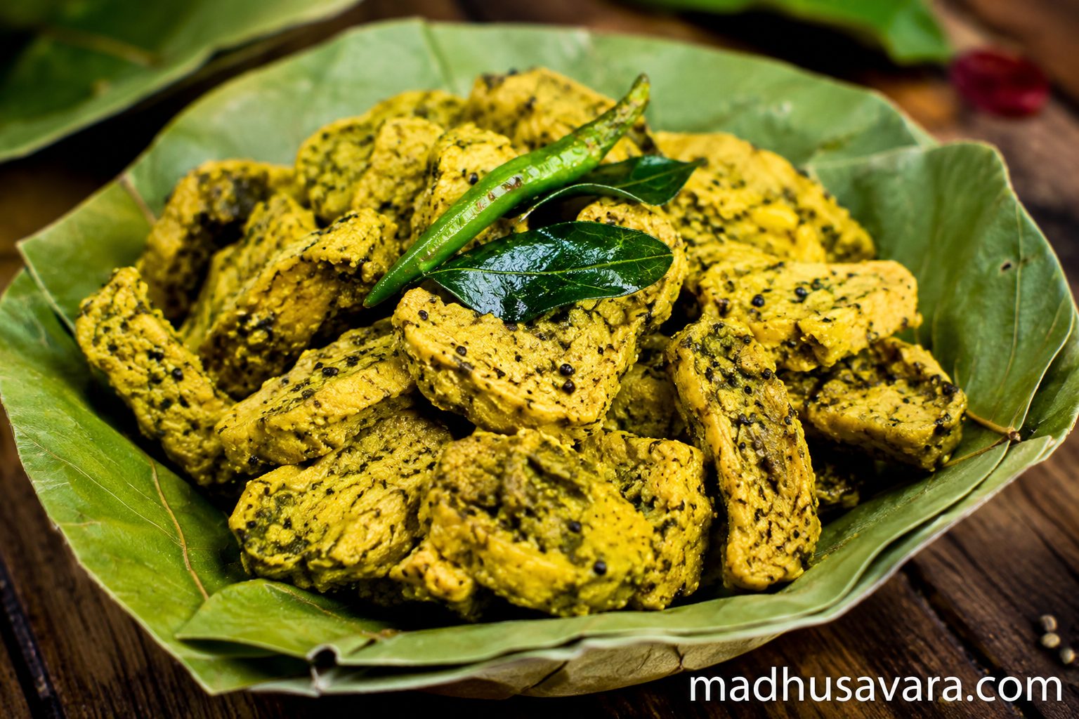 Traditional Himachali Sepu Vadi served in a natural leaf plate, featuring gram lentil dumplings in authentic Kangra-style preparation, photographed in vibrant high-resolution food photography with rich colours and rustic presentation.