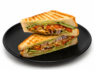 Authentic Bombay Sandwich layered with fresh vegetables, butter, mint chutney and cheese, grilled until golden brown and served as one of Mumbai's most popular Indian street food sandwiches.