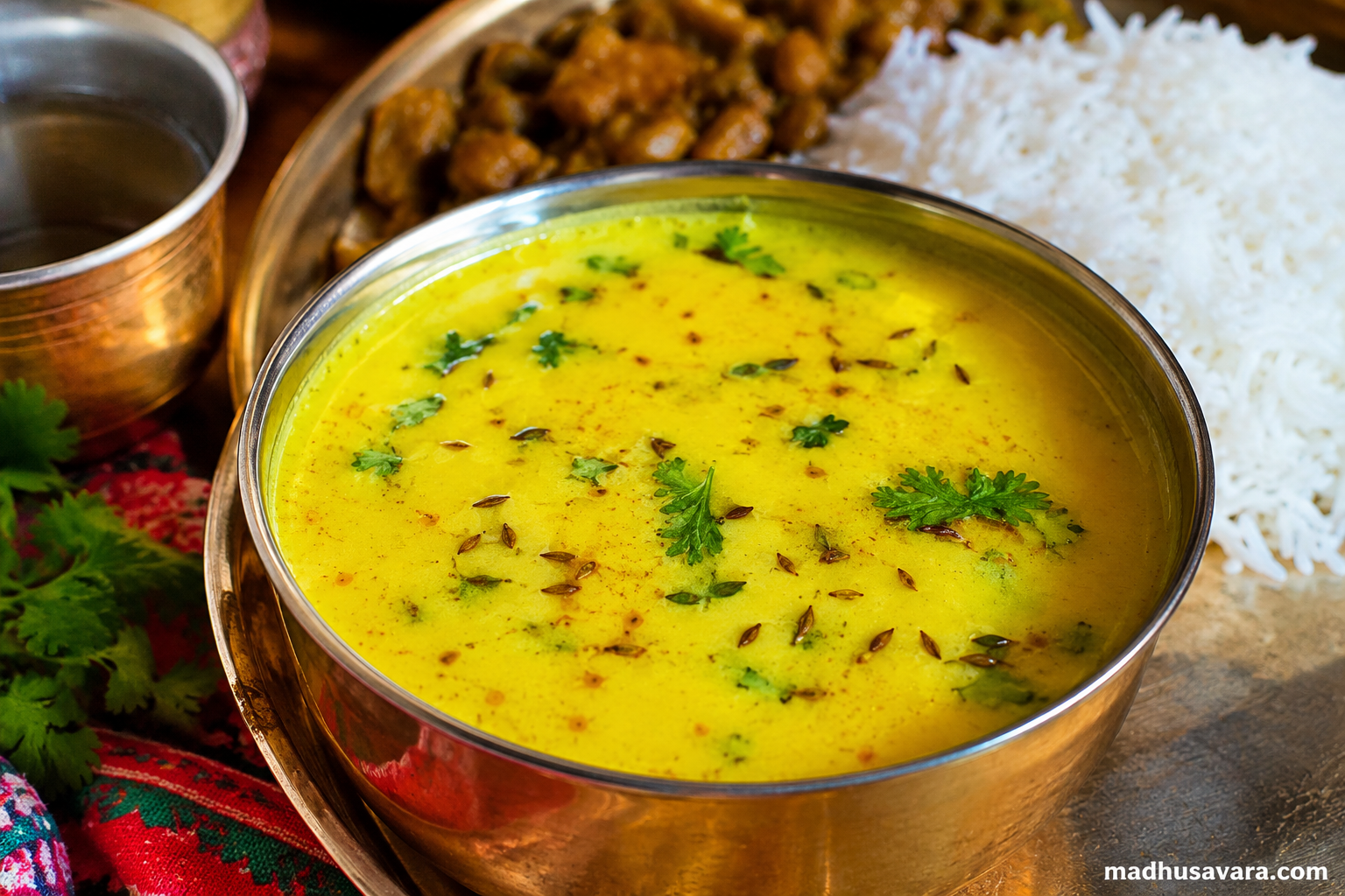 Authentic Mandyali Buttermilk Jhol served in a traditional brass bowl with steamed rice, the refreshing final course of a traditional Mandyali Dham from Himachal Pradesh.