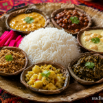 Authentic Kangri Dham boiled rice served on a traditional leaf plate with fluffy long-grain white rice, photographed in vibrant high-resolution with a rustic Himachali festive presentation