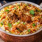 Authentic Lucknowi Biryani Recipe served in a traditional copper handi with saffron-infused basmati rice, tender dum-cooked mutton, crispy fried onions, fresh mint, and aromatic Awadhi spices.