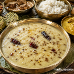 Authentic Dhuli Mah Ki Dal served in a traditional brass bowl on a leaf plate with steamed rice and Mandyali Dham dishes, topped with a fragrant ghee tadka of cumin and dried red chillies.