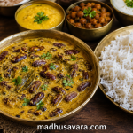 Authentic Rajmah Madra Recipe served in a traditional brass bowl with steamed Dham rice, Chana Madra, Chambyalli Kala Chana Khatta and curd on a rustic wooden table, showcasing the rich flavours of Chambyalli Dham from Chamba, Himachal Pradesh.