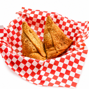 Authentic crispy Punjabi Samosa served in a paper basket, showcasing golden flaky pastry with a traditional potato filling, one of India's most popular street food snacks. Image courtesy: Halwai's – The Desi Chef.