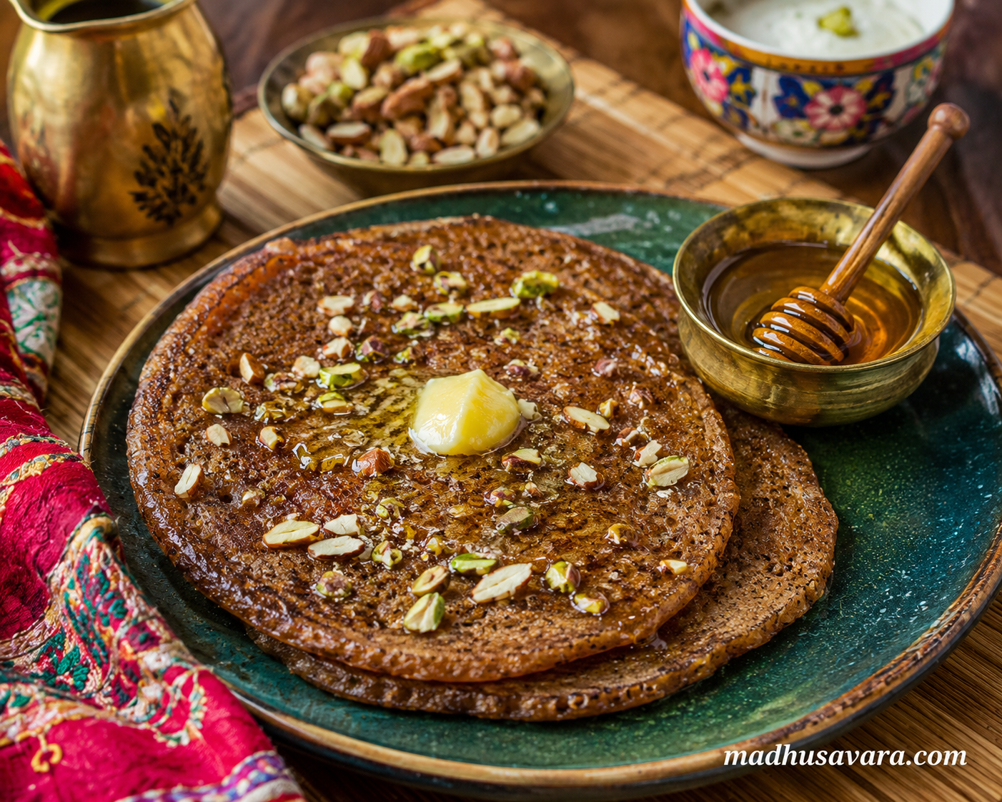 Himachali Aktori Served with Ghee, Honey and Nuts Himachali Aktori pancakes served with ghee, honey, nuts and curd on a traditional table setting.