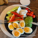 High protein breakfast plate with boiled eggs, Polish Twaróg cheese, avocado, cucumber, red bell pepper and cherry tomatoes